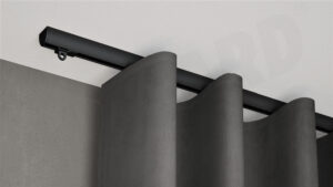 Schwarze 1-läufige Aufputz-Gardinenschiene Modell 410 mit grauem Vorhang, verdeckt montiert an weißer Decke.
