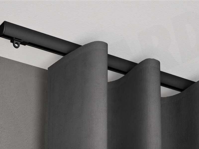 Schwarze 1-läufige Aufputz-Gardinenschiene Modell 410 mit grauem Vorhang, verdeckt montiert an weißer Decke.