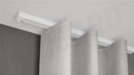 Weiße 1-läufige Aufputz-Gardinenschiene Modell 450 mit Vorhang, verdeckt montiert und biegsam angepasst an Decke.