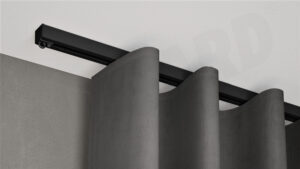 Schwarze 1-läufige Aufputz-Gardinenschiene Modell 450 mit fließendem Vorhang, verdeckt montiert an weißer Decke.