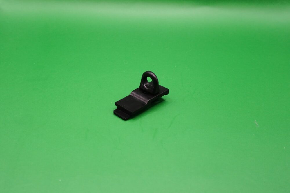 Endfeststeller schwarz Gardinenschienen 6 mm Schwarzer Endfeststeller aus Kunststoff für Gardinenschienen mit 6 mm Laufbreite auf grünem Hintergrund.